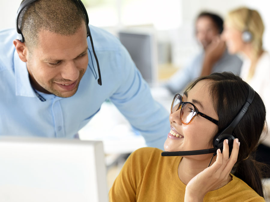 call center team leader coach assisting customer service rep at works