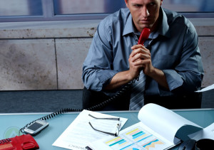 businessman-thinking-while-holding-telephone