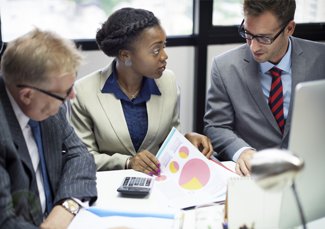 diverse business team in meeting looking at reports charts graphs