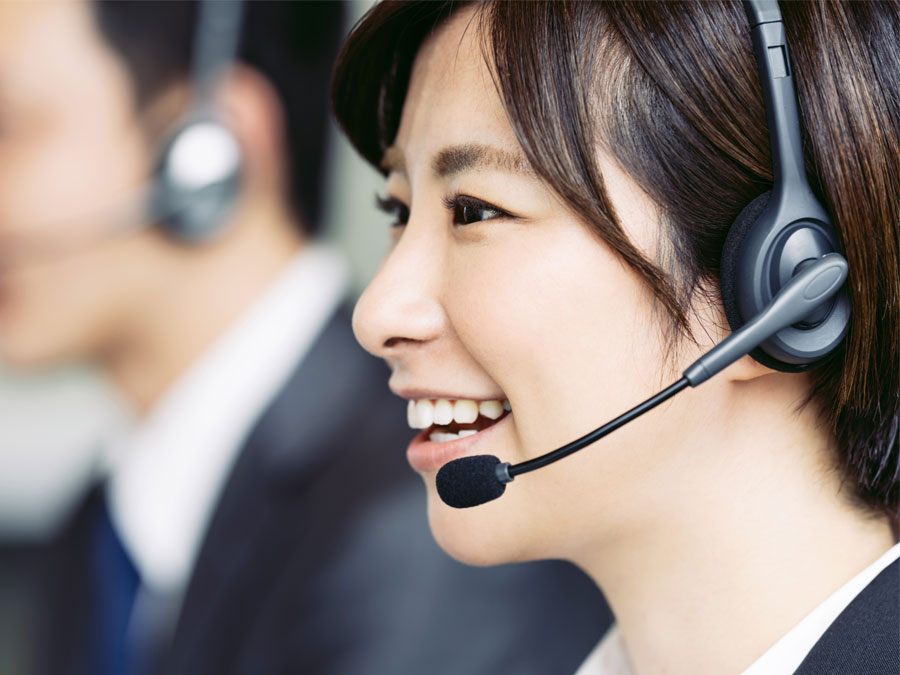 smiling japanese call center agent assisting caller over the phone