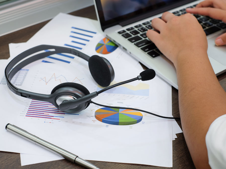 call center team leader typing on keyboard next to customer service statistics