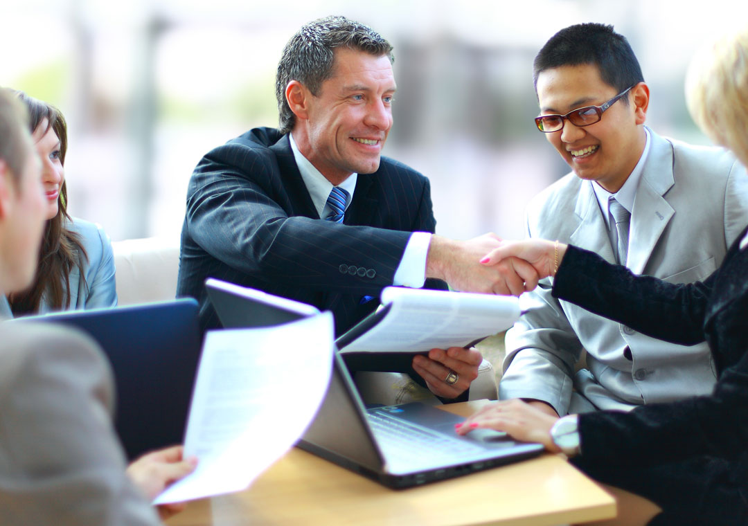 business executives shaking hands with outsourcing partner