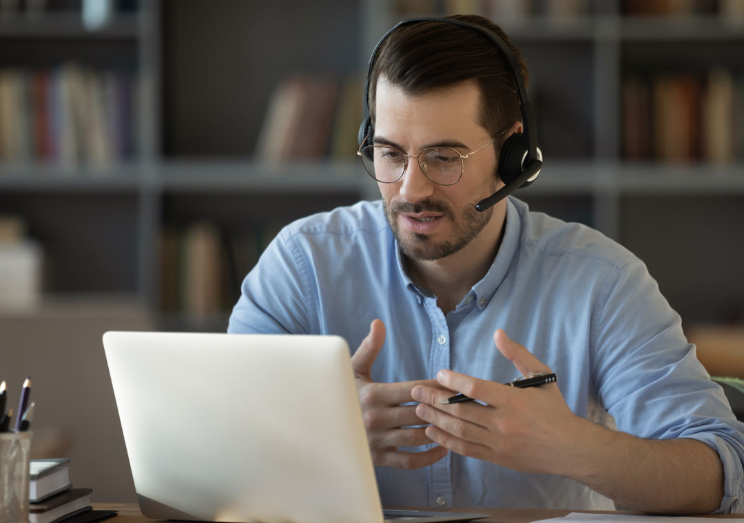 customer care agent sppeaking to caller looking at laptop