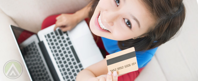 female-customer-holding-laptop-and-credit-card