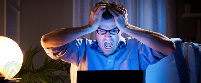 man-in-glasses-panicking-in-front-of-laptop-in-dark-room