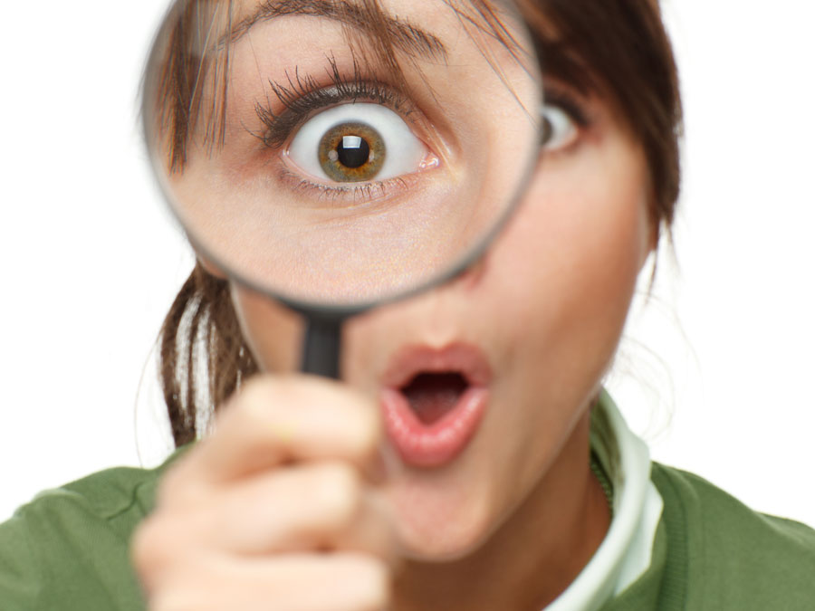 woman delighted looking through magnifying lens