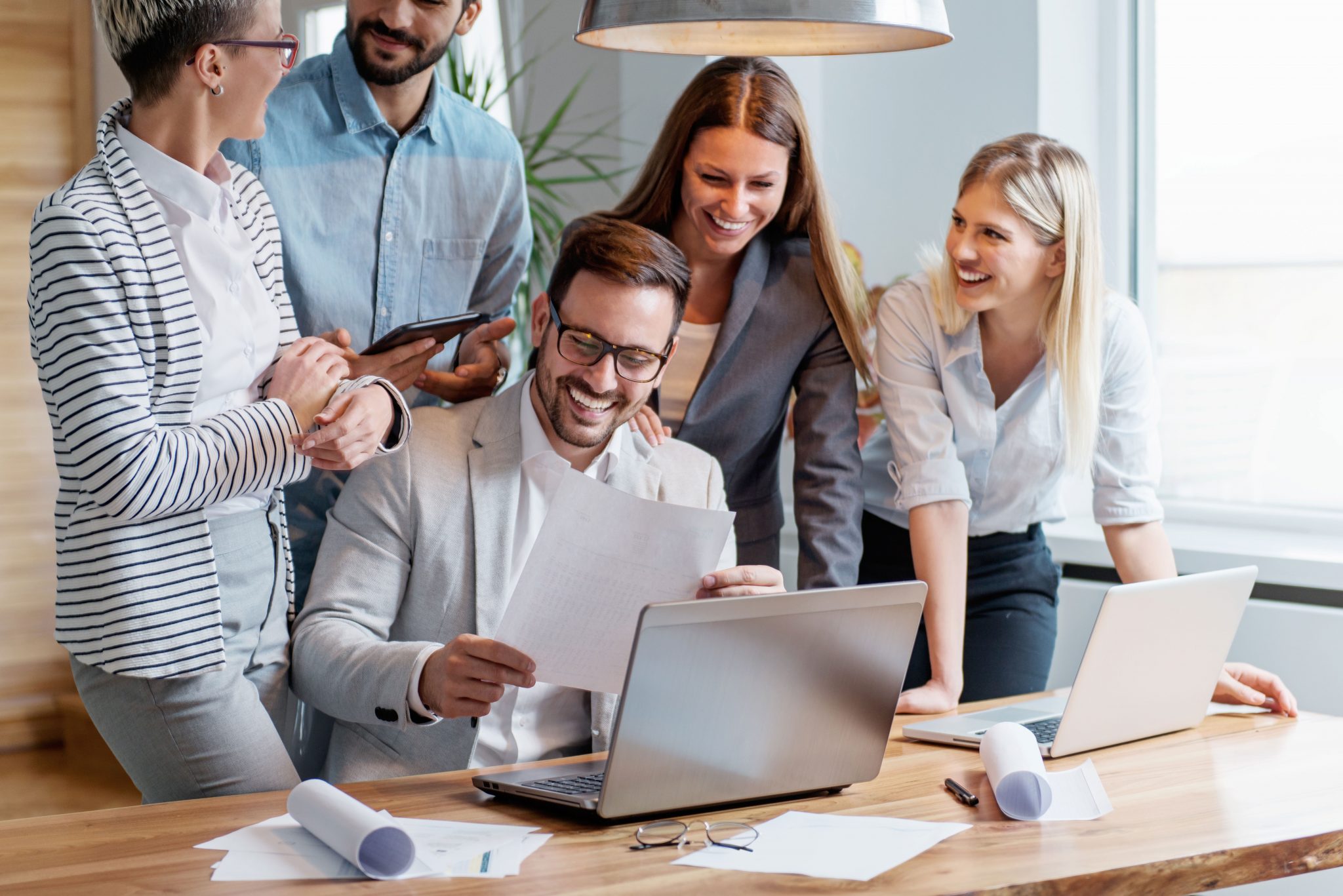 business team laughing happy over laptop