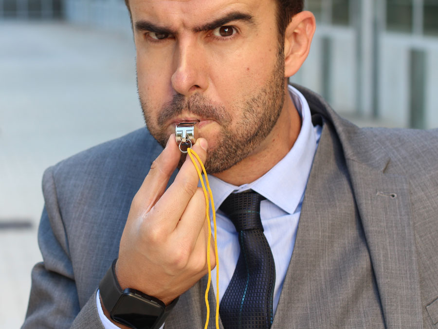 businessman using policeman whistle