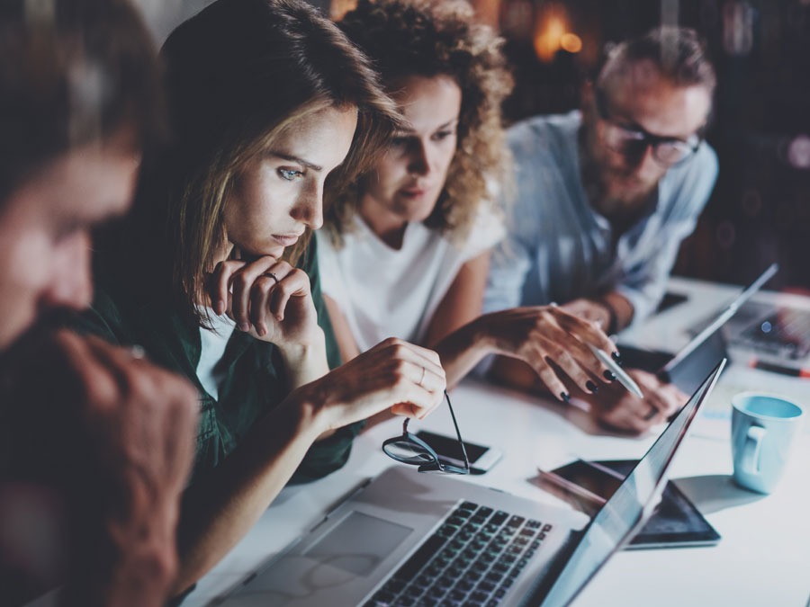 content moderation team with leader discussing document on laptop