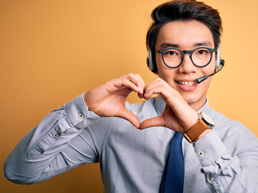 Asian customer service agent in call center making hearts