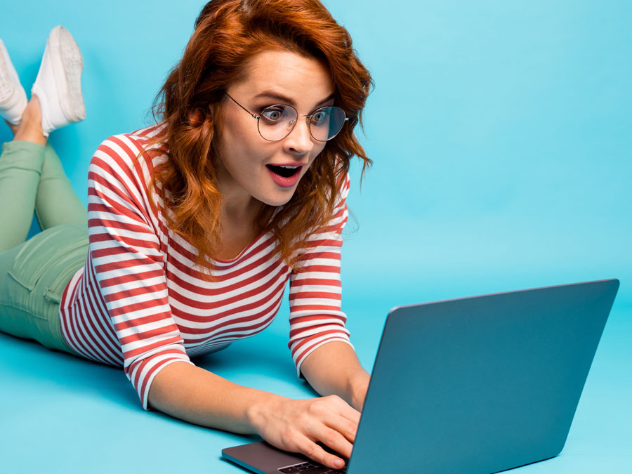 happy woman using laptop on the floor