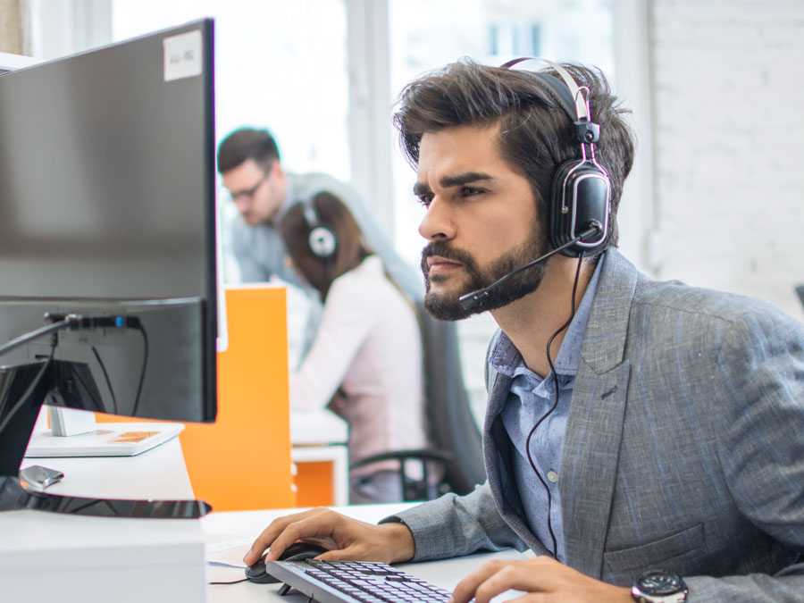 customer service agent in call center looking intently at computer screen