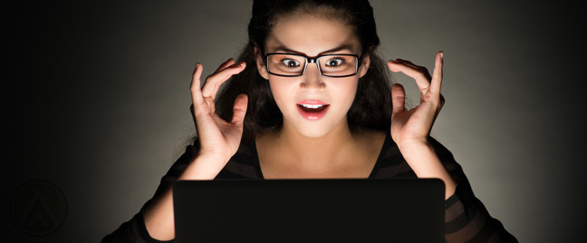 asian-woman-in-the-dark-amazed-at-laptop