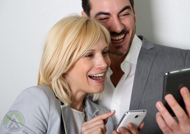 couple-smiling-laughingat-smartphones