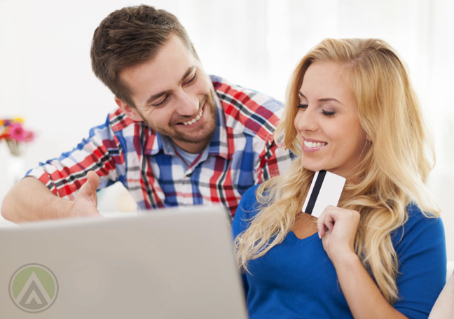 smiling-couple-on-ecommerce-site-on-laptop