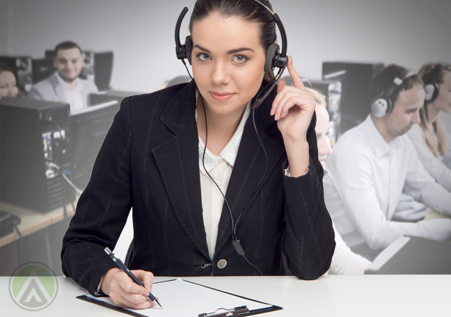 female-quality-assurance-agent-listening-to-customer-service-call-with-call-center-agents-in-the-back