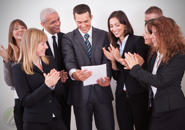 diverse-business-team-applauding-member-reading-paper-document