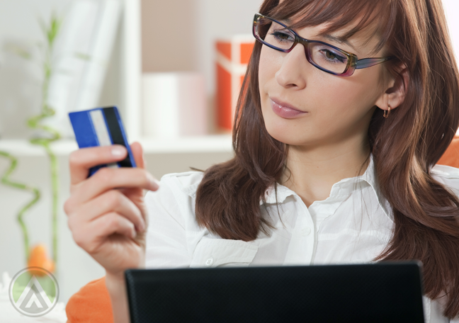 woman-in-glasses-in-front-of-laptop-staring-at-credit-card