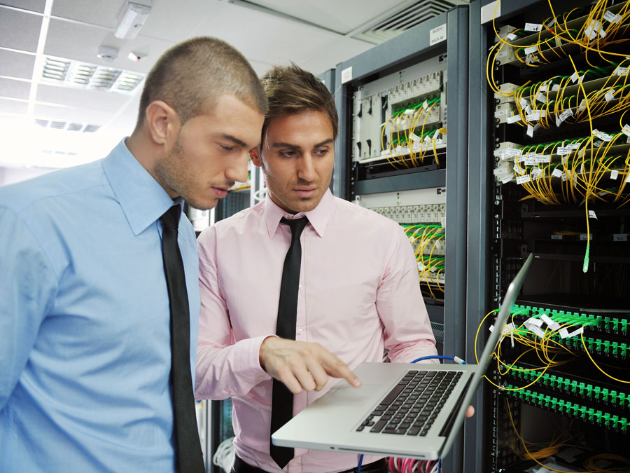 IT helpdesk staff in server room checking equipment