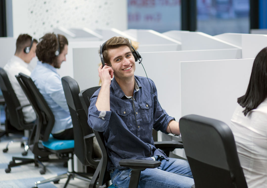 smiling customer care agent with call center team