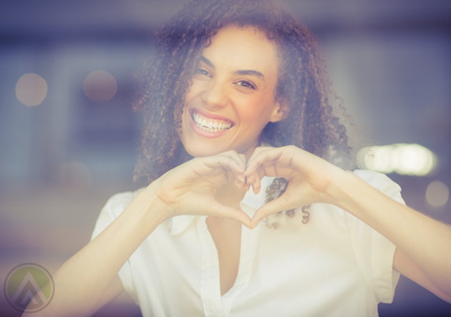 woman-forming-heart-with-hand-behind-glass-pane