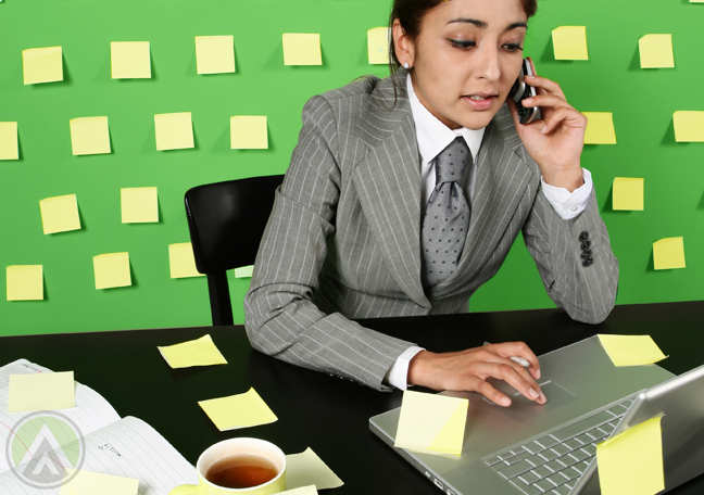 female-business-executive-on-phone-call-using-laptop