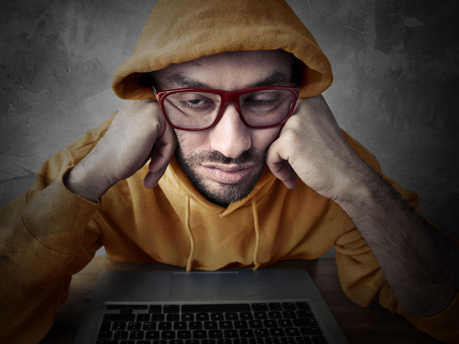 social media marketing failure depiction bored man in hood using laptop