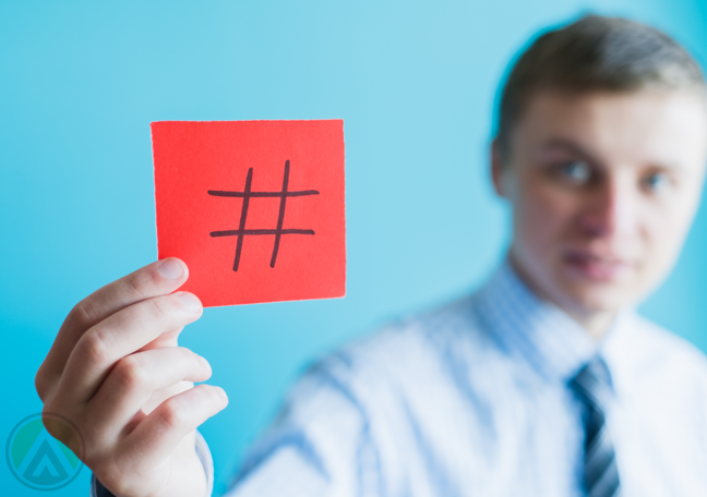 young-office-employee-holding-red-post-it-not-with-hashtag