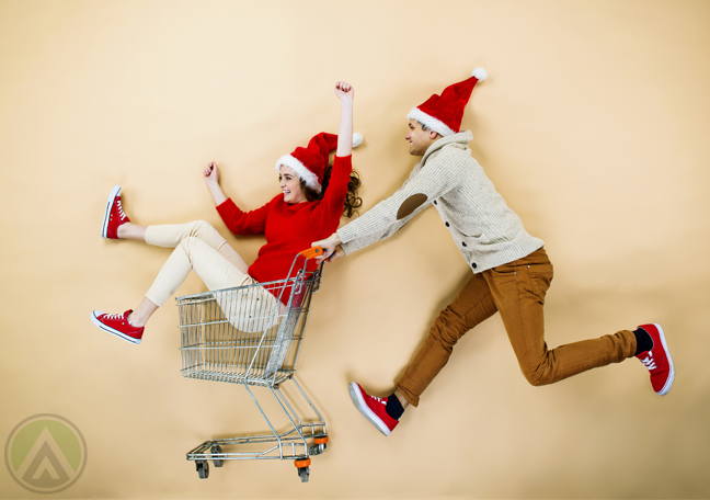 couple-in-santa-hat-rushing-to-store-on-shopping-cart