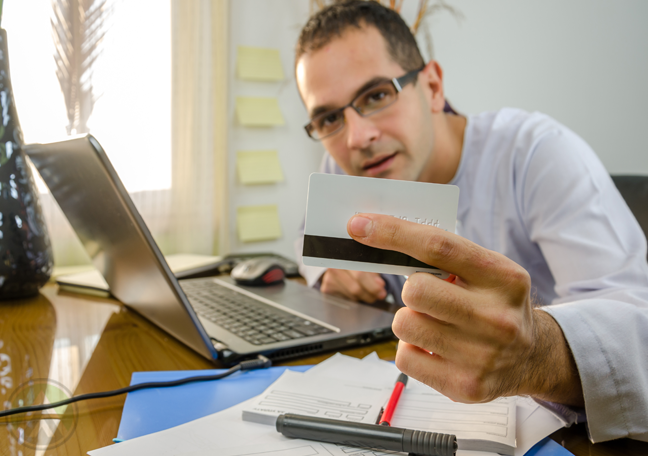 iran-man-with-laptop-holding-credit-card