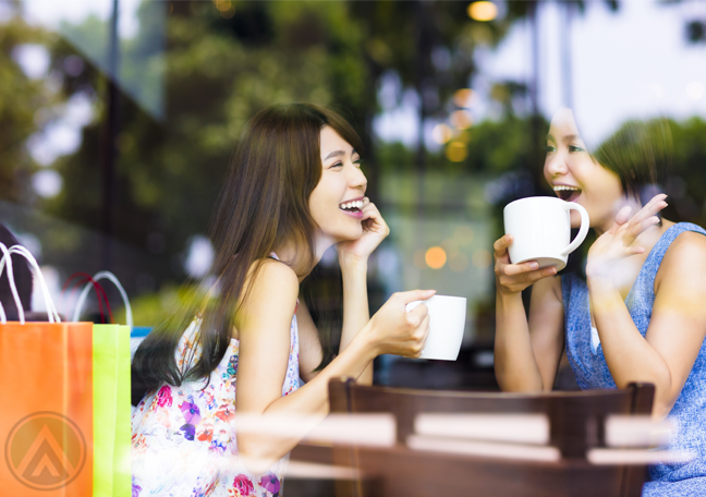 women-at-cafe-shop-laughing-over-coffe-with-shopping-bags