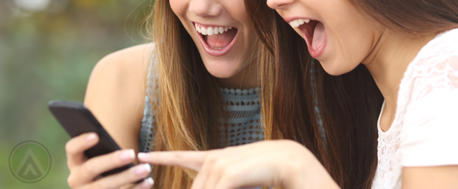 happy-excited-women-looking-at-smartphone