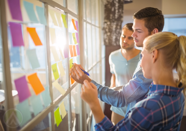 business-creative-team-writing-on-postit-notes-on-window