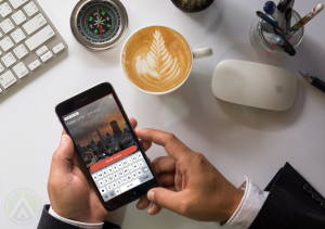 businessman-hands-using-Persiscope-mobile-app-capuccino-mouse-keyboard-compass