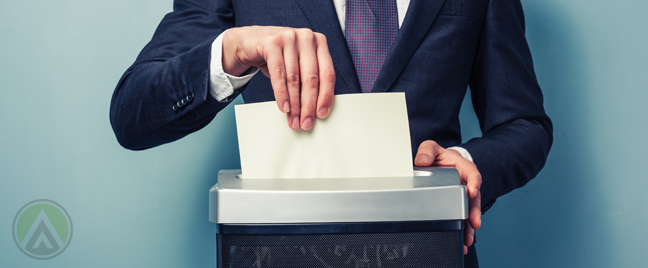 businessman-pushing-paper-into-shredder