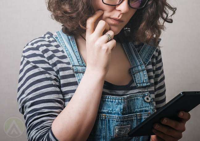 woman-with-curly-hair-reading-tablet