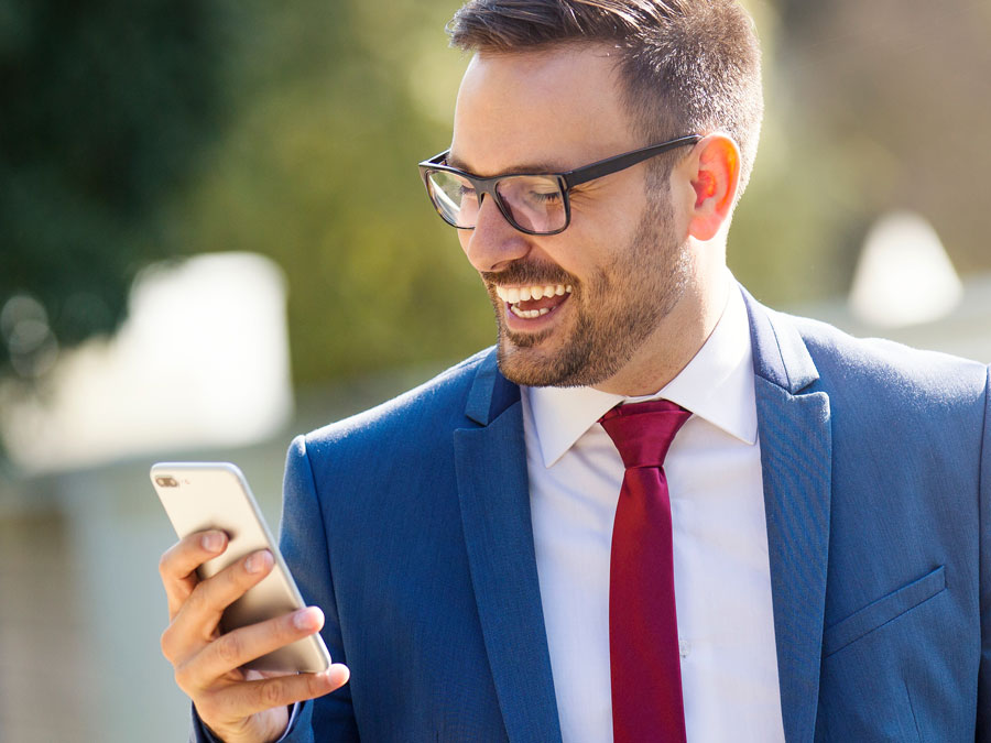 smiling man looking at ecommerce site customer support on phone