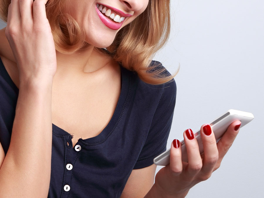 smiling woman looking at smartpohone on ecommerce shopping site