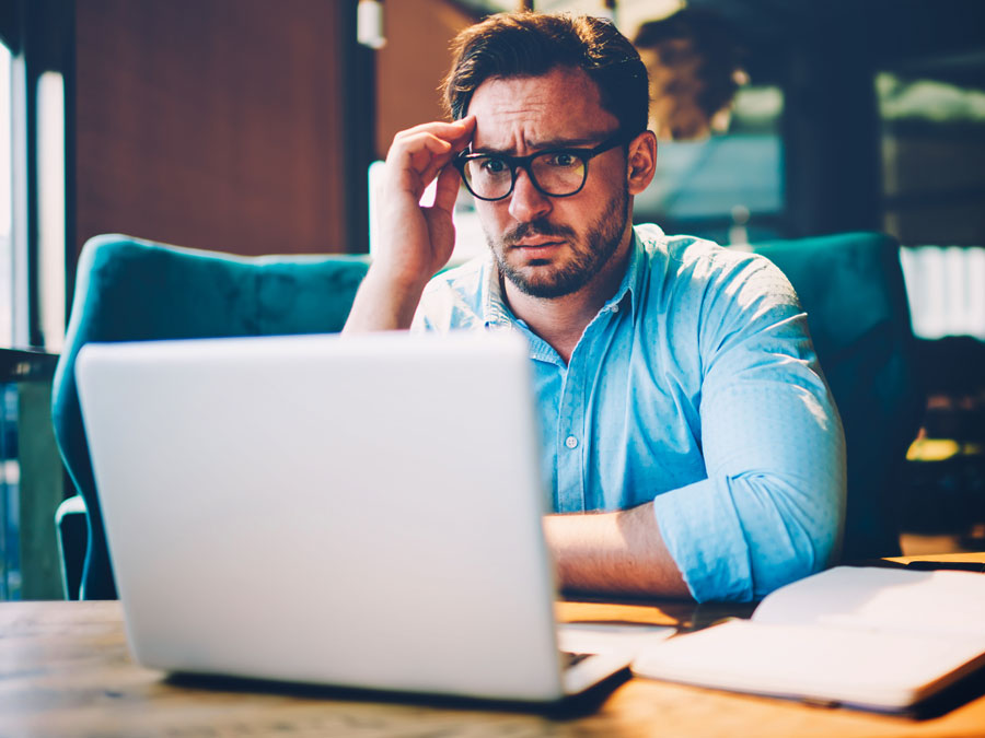 confused thinking businessman focused on laptop