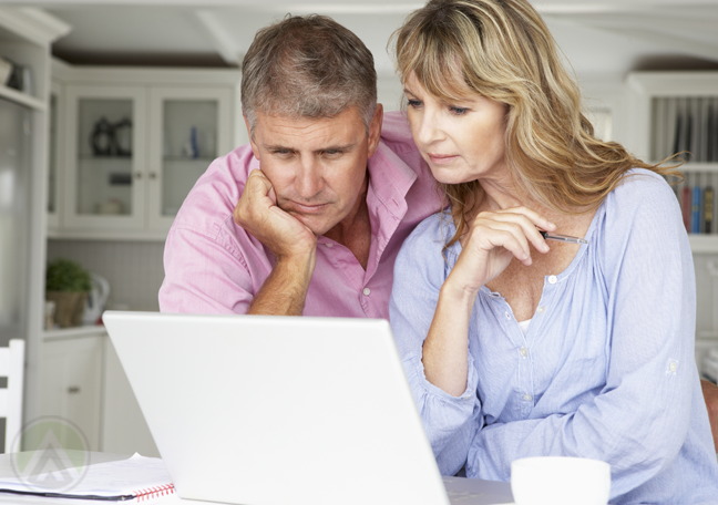 middle-aged-couple-reading-laptop