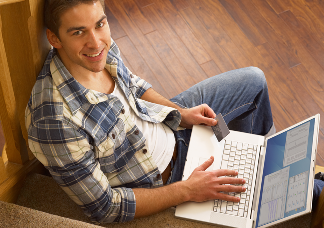 smiling-young-man-using-laptop-on-the-stairs-landing