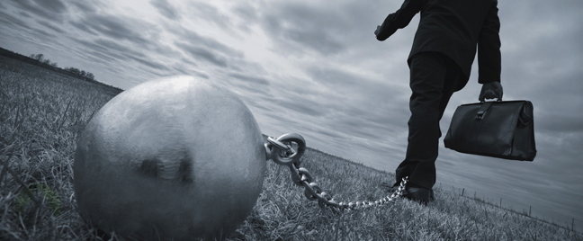 businessman-walking-slowly-with-ball-and-chain