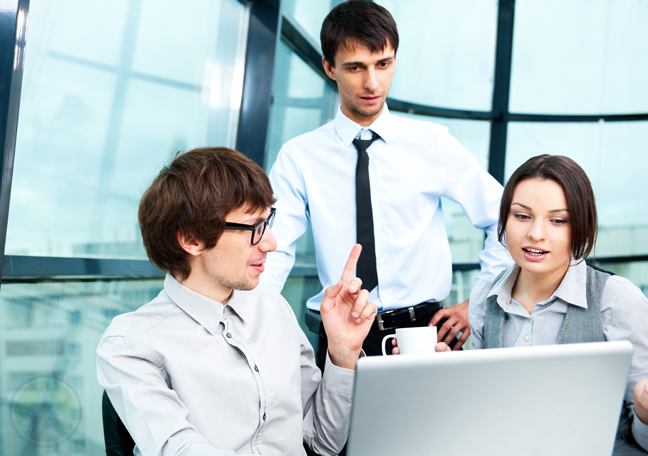 coworkers-chatting-in-front-of-laptop-with-team-leader-watching