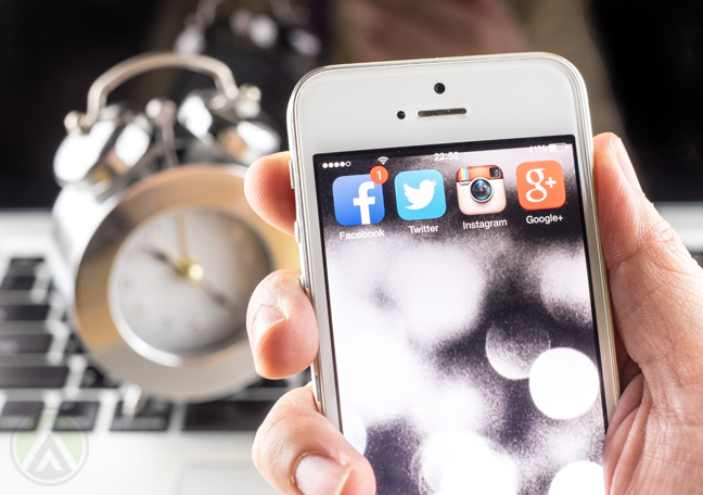 hand-holding-smartphone-near-keyboard-alarm-clock