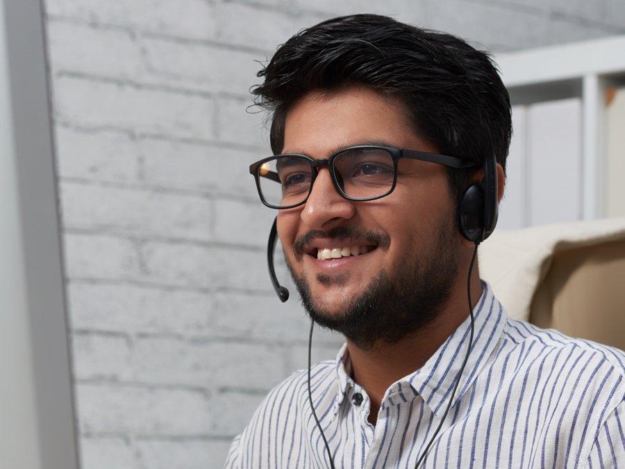 smiling call center agent looking at computer screen