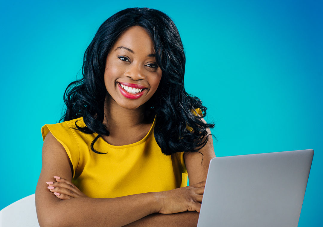 smiling social media customer service agent in call center using laptop