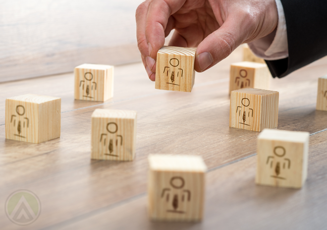 businessman-hand-holding-wooden-blocks-human-figures