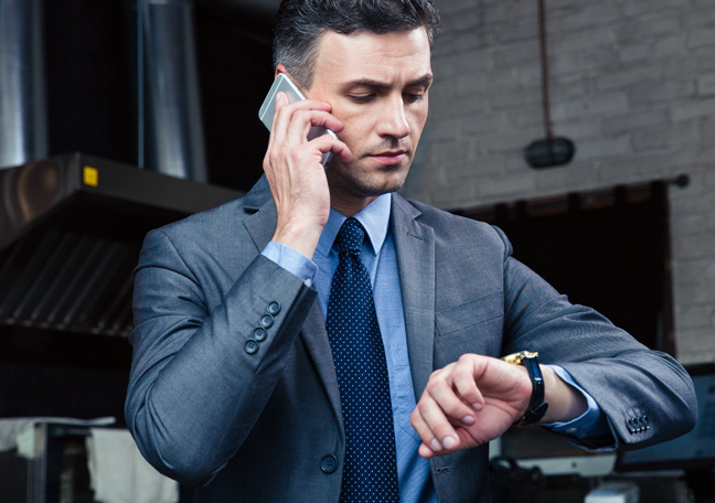 businessman-in-a-phonceall-looking-at-wrist-watch