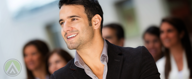 businessman-looking-up-surrounded-by-coworkers