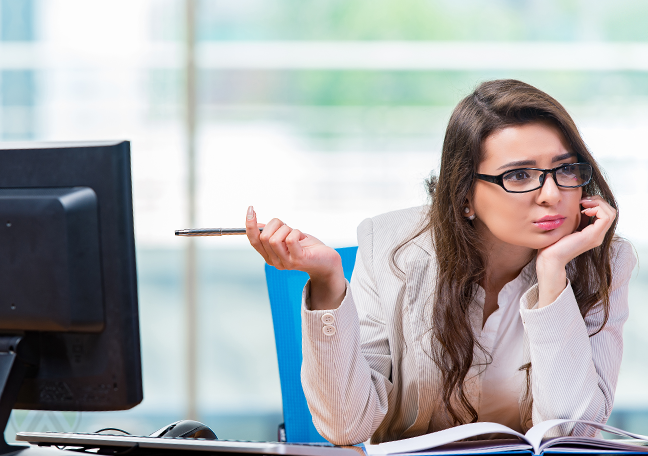 confused-office-worker-pointing-to-computer-monitor-with-pen